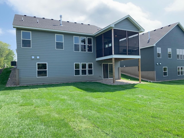 back of property with a sunroom and a yard