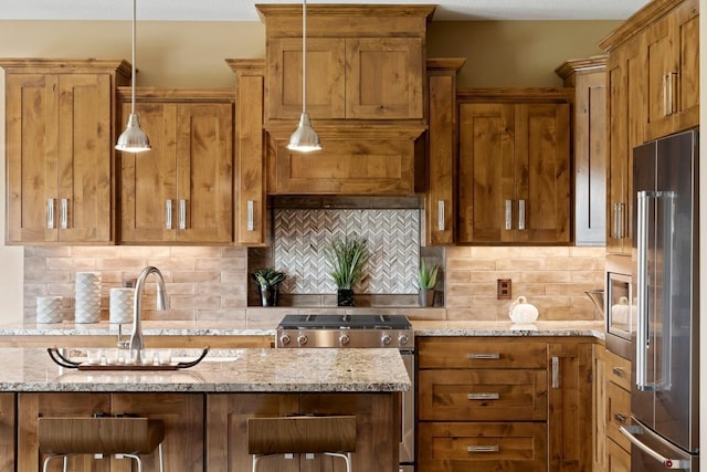 kitchen featuring stainless steel appliances, light stone countertops, decorative light fixtures, and backsplash