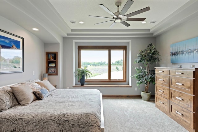 bedroom featuring a tray ceiling, ceiling fan, and carpet floors