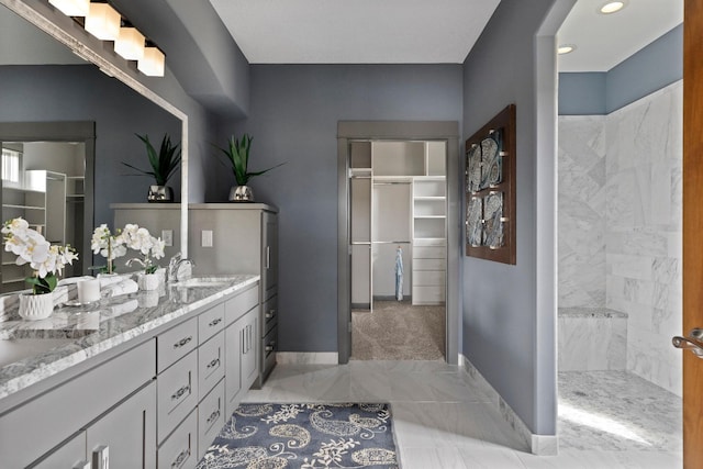 bathroom with tiled shower, vanity, and tile patterned floors