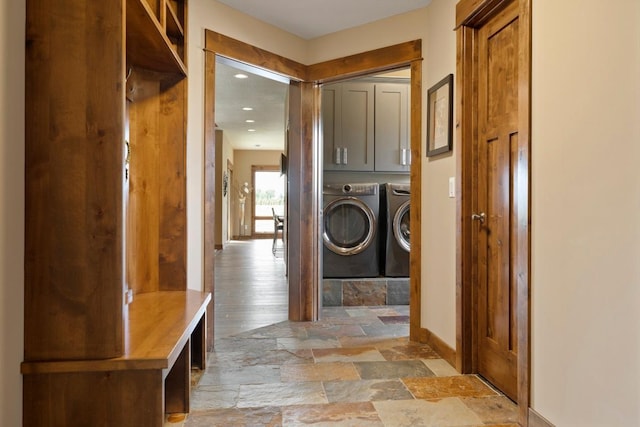 clothes washing area featuring washer and clothes dryer, cabinets, and hardwood / wood-style floors