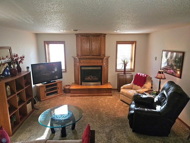 living room featuring a large fireplace, a textured ceiling, and carpet