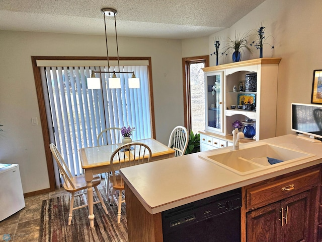 kitchen with sink, pendant lighting, dishwasher, and a textured ceiling