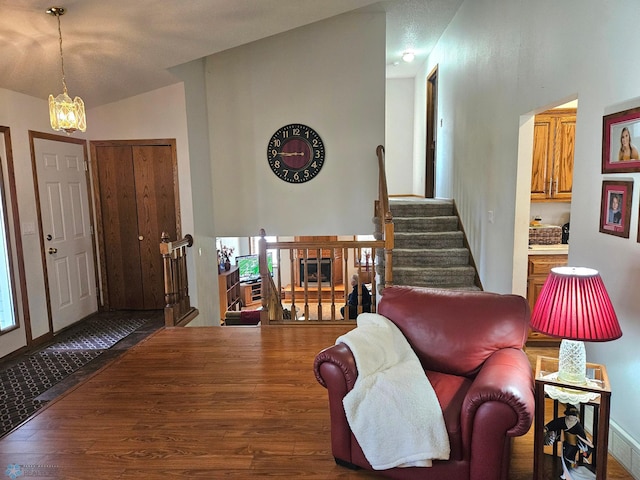 foyer entrance with a notable chandelier, lofted ceiling, and dark hardwood / wood-style floors