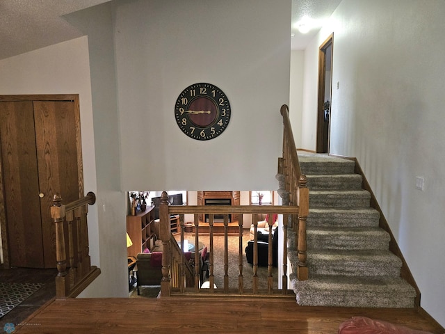 staircase featuring lofted ceiling and wood-type flooring