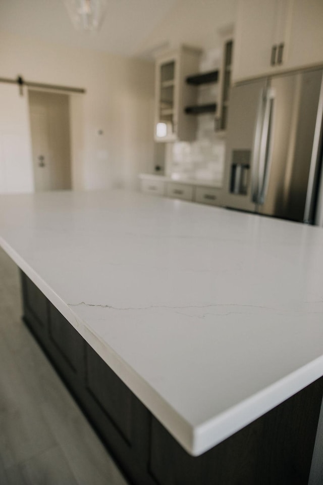 kitchen featuring white cabinets and a barn door