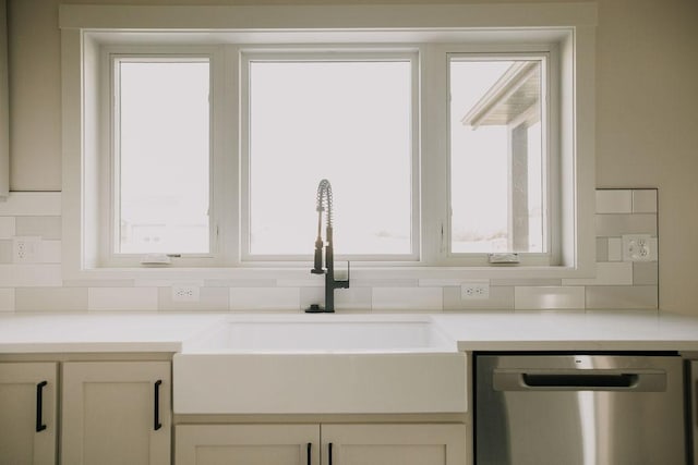 kitchen with backsplash, stainless steel dishwasher, a healthy amount of sunlight, and sink