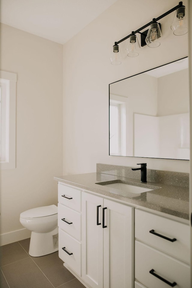 bathroom featuring tile patterned flooring, vanity, and toilet