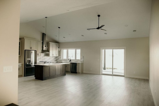 kitchen featuring dishwasher, wall chimney range hood, stainless steel fridge with ice dispenser, light hardwood / wood-style flooring, and a kitchen island