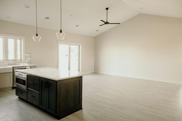 kitchen featuring ceiling fan, decorative light fixtures, light hardwood / wood-style floors, a kitchen island, and lofted ceiling