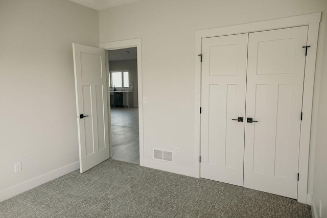 unfurnished bedroom featuring carpet flooring and a closet