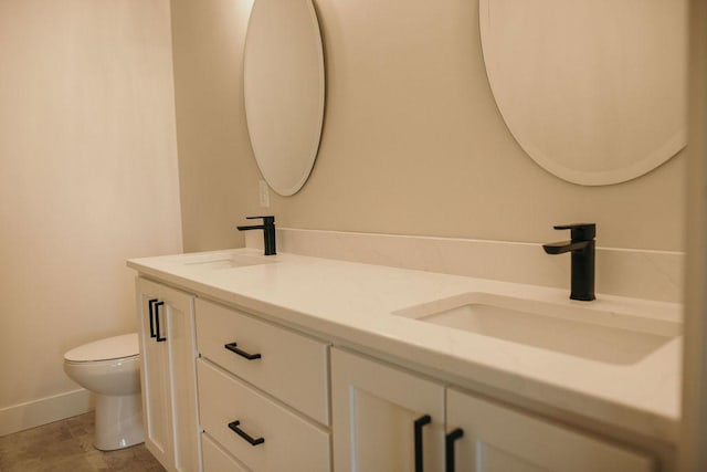 bathroom featuring tile patterned floors, vanity, and toilet