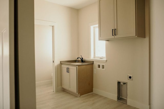 clothes washing area featuring cabinets, sink, light hardwood / wood-style flooring, washer hookup, and hookup for an electric dryer