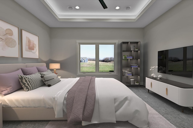 bedroom with a raised ceiling and dark colored carpet