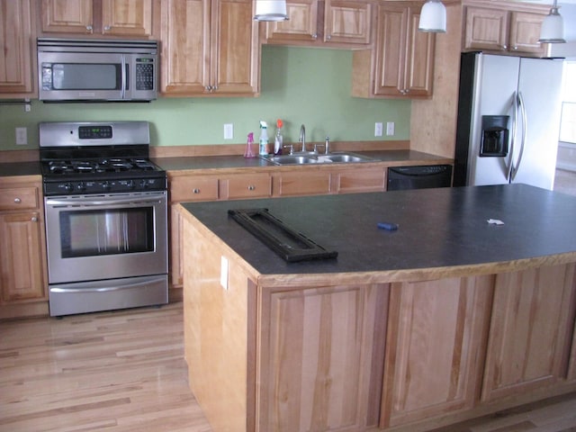 kitchen with a center island, sink, hanging light fixtures, light hardwood / wood-style floors, and stainless steel appliances