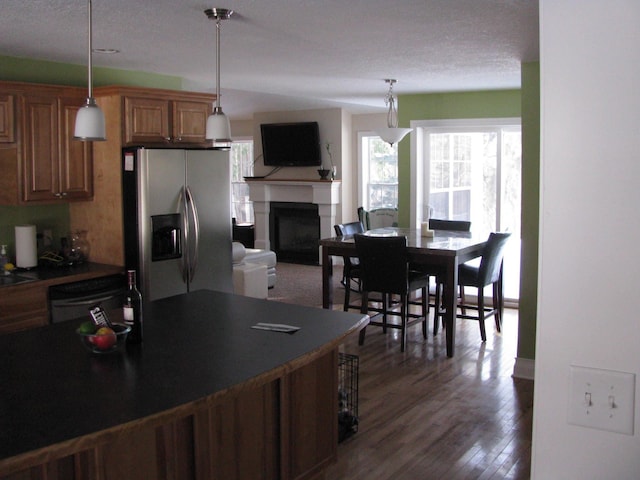 kitchen with dishwasher, pendant lighting, dark hardwood / wood-style floors, and stainless steel refrigerator with ice dispenser