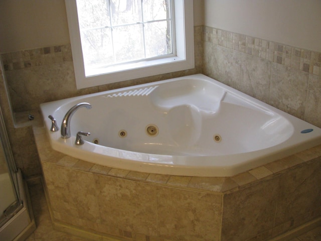 bathroom with tile patterned floors and tiled tub