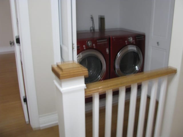 laundry area featuring washing machine and dryer and wood-type flooring