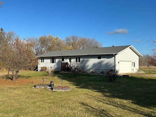 back of house featuring a garage and a lawn