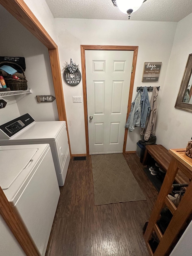 laundry area with a textured ceiling, dark hardwood / wood-style flooring, and independent washer and dryer