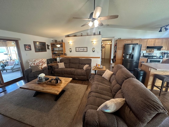 living room featuring dark wood-type flooring, vaulted ceiling, ceiling fan, and a textured ceiling