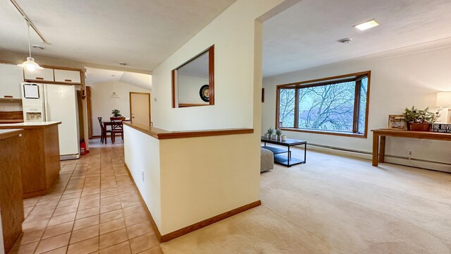 hallway with lofted ceiling and light tile patterned floors