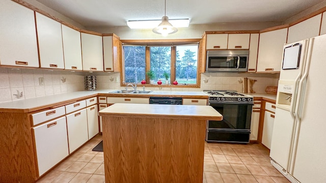 kitchen featuring white cabinets, a center island, gas range oven, and white refrigerator with ice dispenser