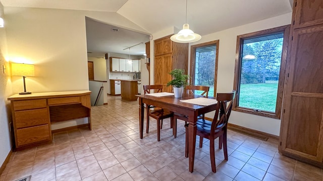 tiled dining area with lofted ceiling and plenty of natural light