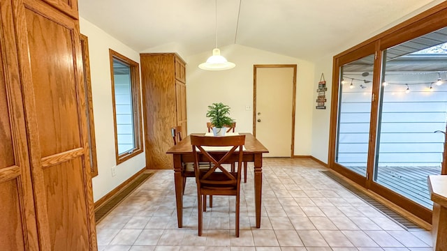 tiled dining area featuring vaulted ceiling