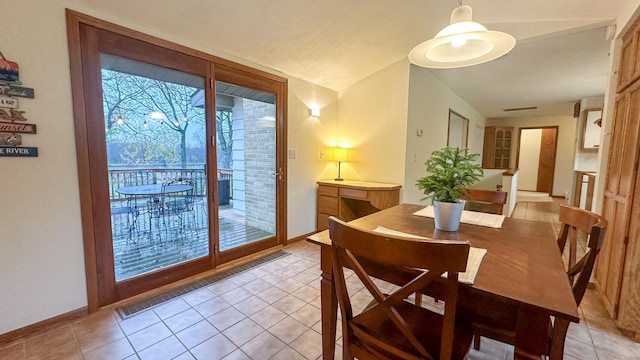 dining area featuring lofted ceiling and light tile patterned flooring