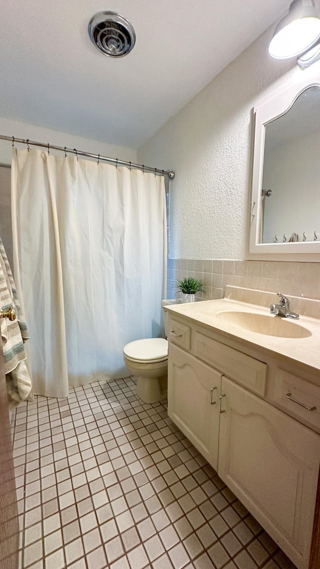 bathroom featuring tile patterned flooring, vanity, and toilet