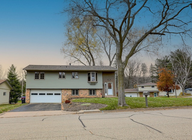 split foyer home featuring a yard and a garage