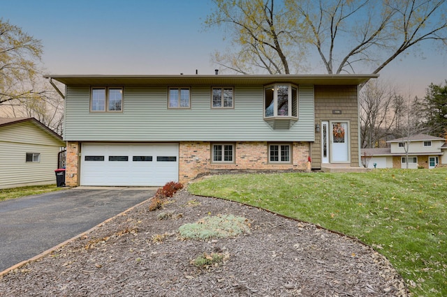 bi-level home featuring a yard and a garage