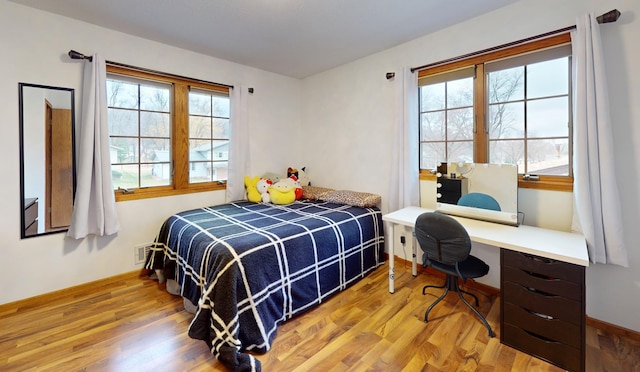 bedroom featuring light hardwood / wood-style floors and built in desk