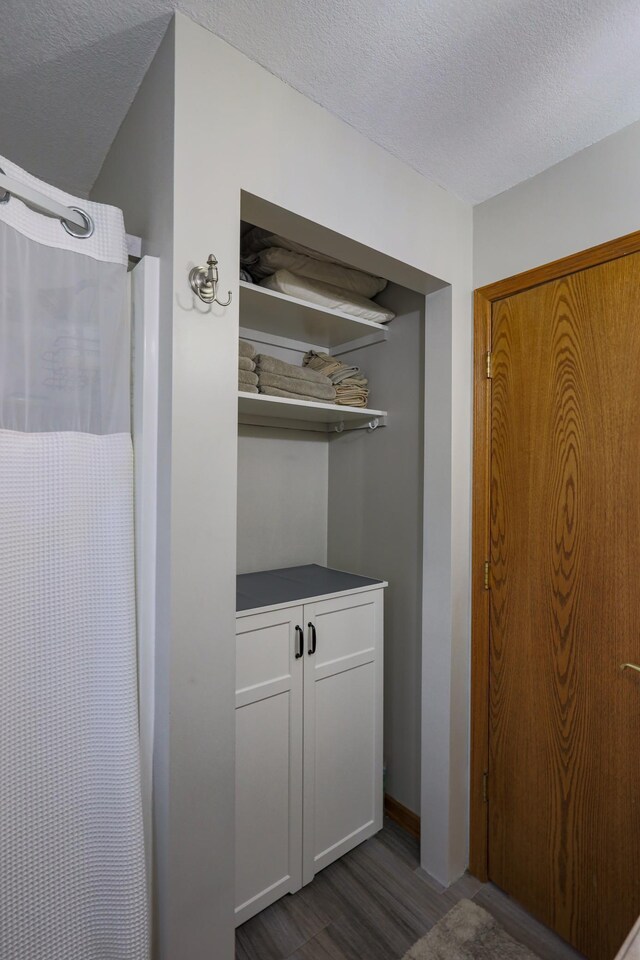 interior space featuring vanity, hardwood / wood-style floors, and a textured ceiling