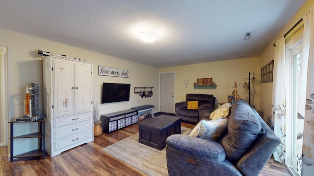 living room with dark hardwood / wood-style flooring and a textured ceiling