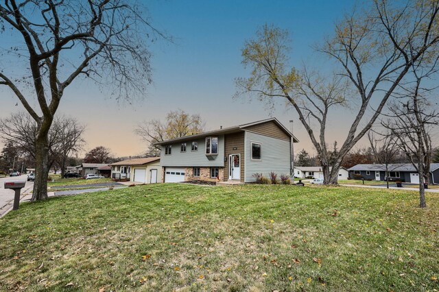 raised ranch featuring a yard and a garage