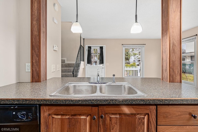 kitchen with dishwasher, hanging light fixtures, and sink