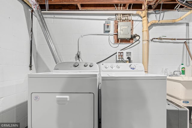 clothes washing area with sink, electric panel, and washing machine and clothes dryer