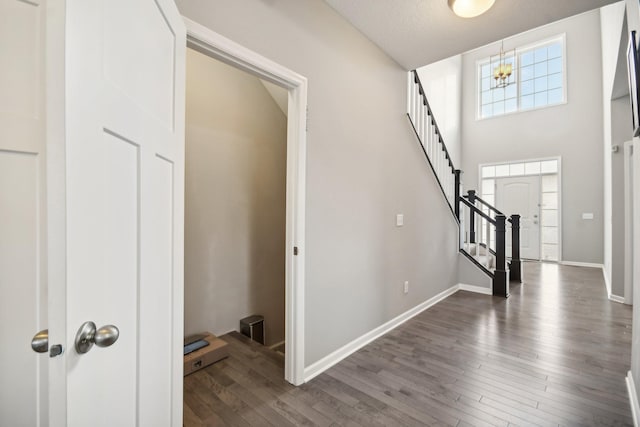 entryway with hardwood / wood-style flooring, a textured ceiling, an inviting chandelier, and high vaulted ceiling