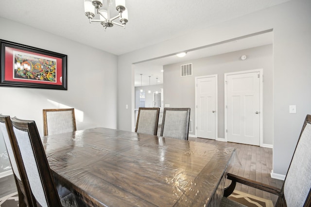 dining room featuring wood-type flooring and a chandelier