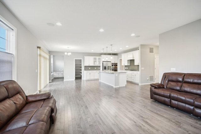 living room with wood-type flooring and an inviting chandelier