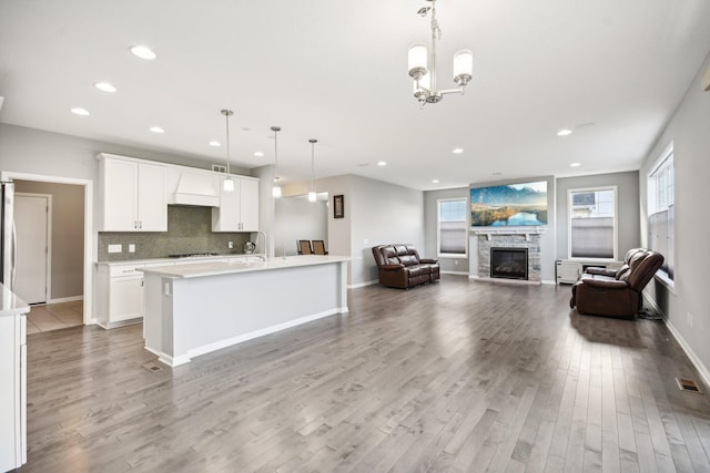 kitchen featuring hanging light fixtures, white cabinetry, and light hardwood / wood-style flooring