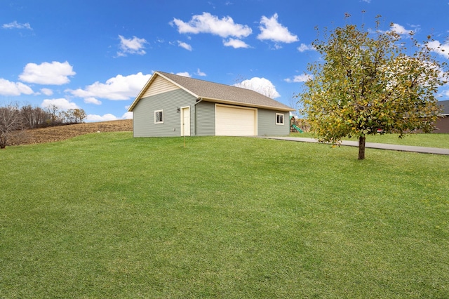 back of property featuring a garage and a lawn