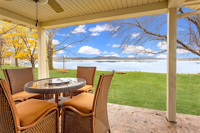 view of patio with a water view and ceiling fan