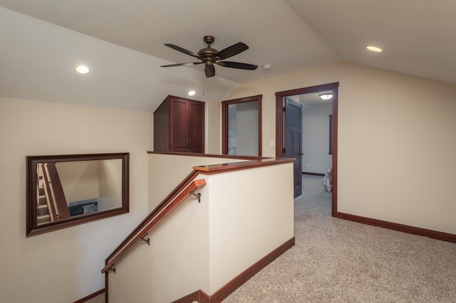 corridor with light carpet and vaulted ceiling