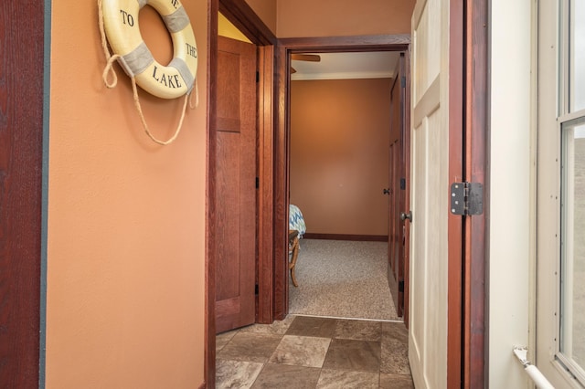 hall featuring dark carpet and crown molding