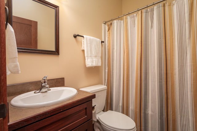 bathroom with vanity, toilet, and walk in shower