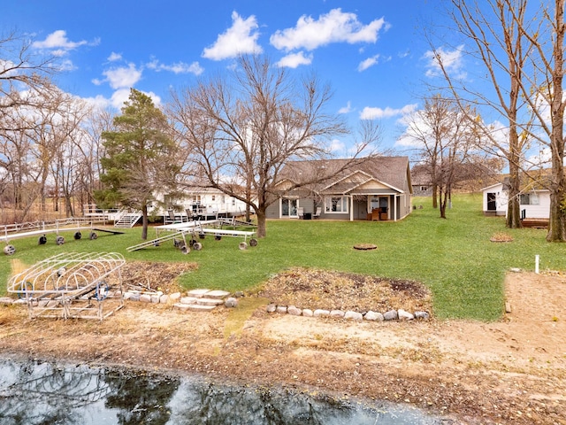 rear view of property with a yard and a water view