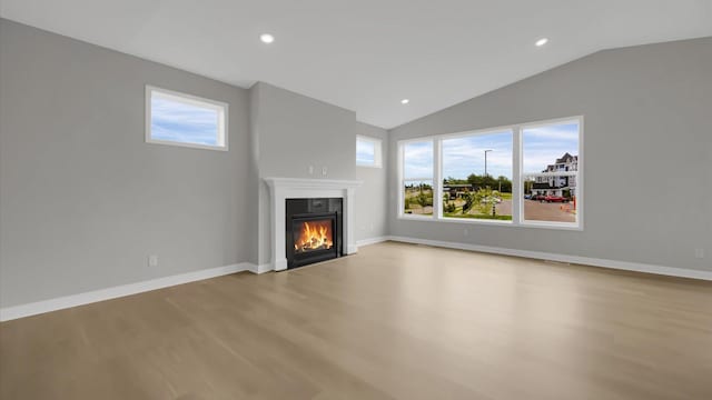 unfurnished living room featuring lofted ceiling and light hardwood / wood-style floors